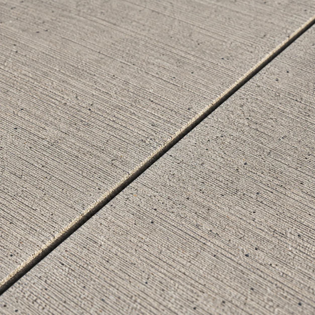 Close view of broom-finished concrete and a joint